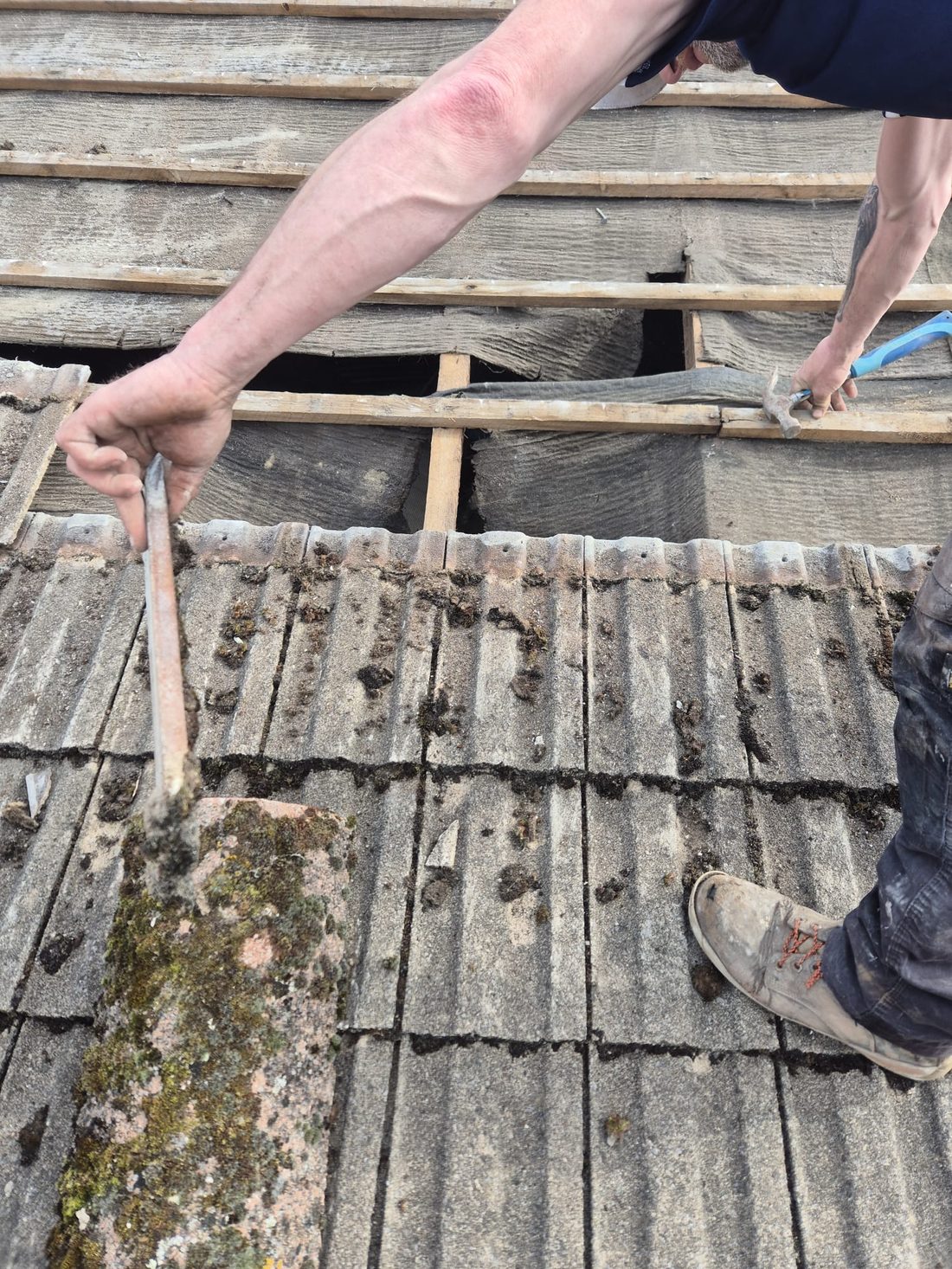 Roof repair in progress, lifting tiles